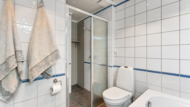 Dusjnisjen har glassvegg og glassdør. Badet har mekanisk avtrekksvifte i himlingen.