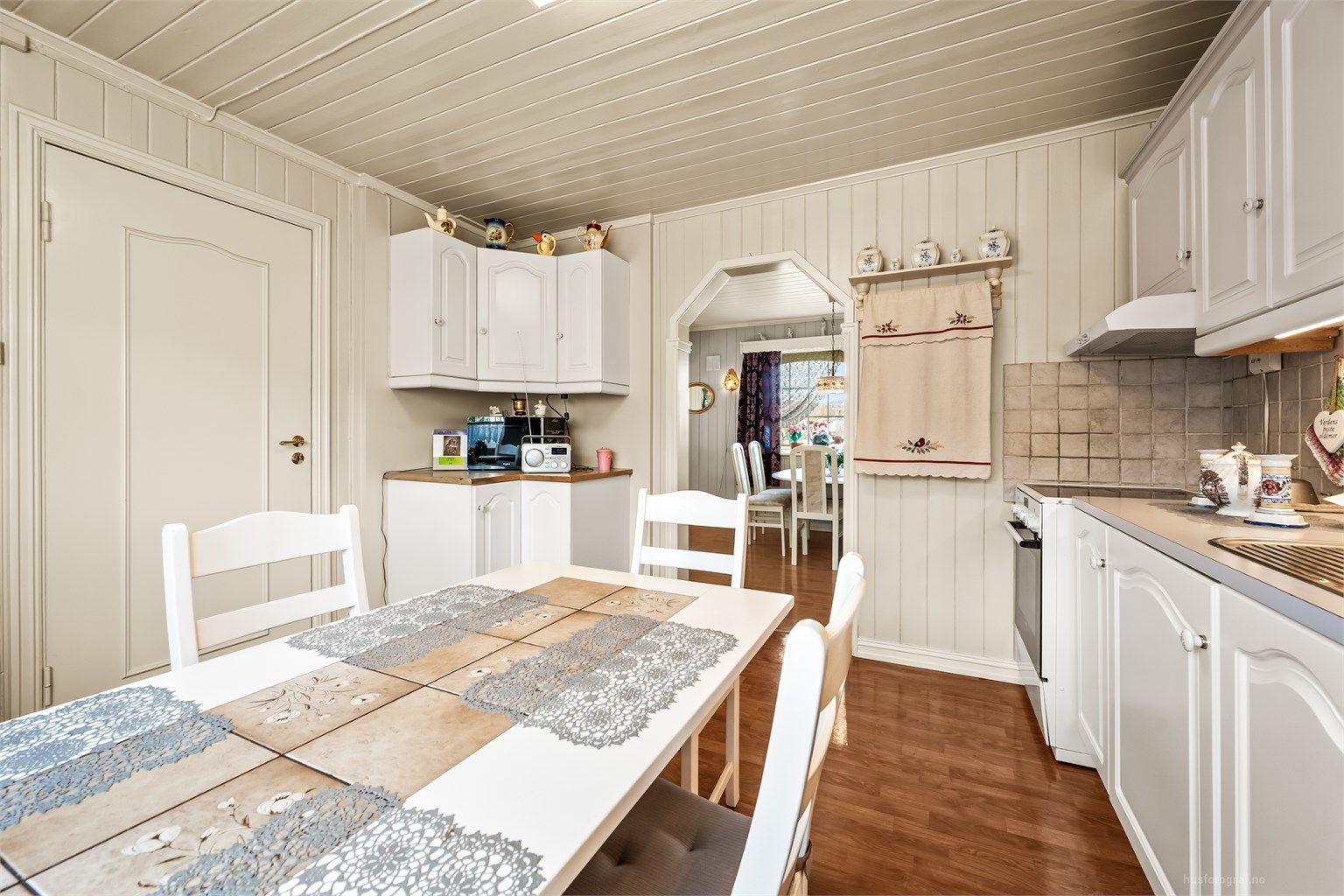 En åpen buegang forbinder kjøkkenet med spisestuen, noe som gir en god flyt mellom rommene.