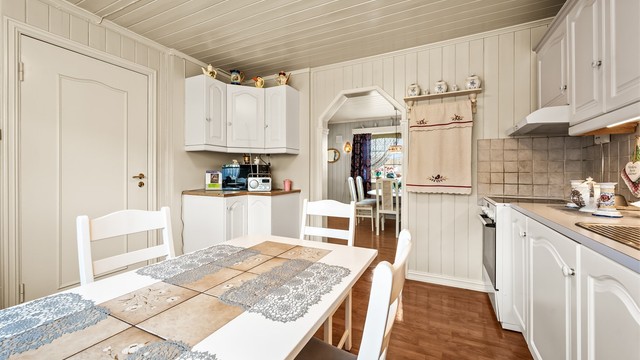 En åpen buegang forbinder kjøkkenet med spisestuen, noe som gir en god flyt mellom rommene.