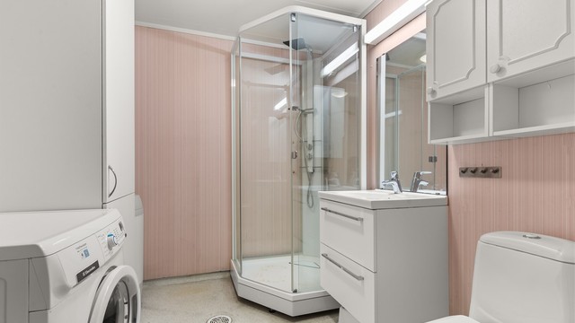 Badet er utstyrt med dusjkabinett, opplegg for vaskemaskin og elektrisk gulvvarme. Rommet har et betydelig oppgraderingsbehov og representerer en spennende mulighet til å etablere et moderne bad etter egen smak.