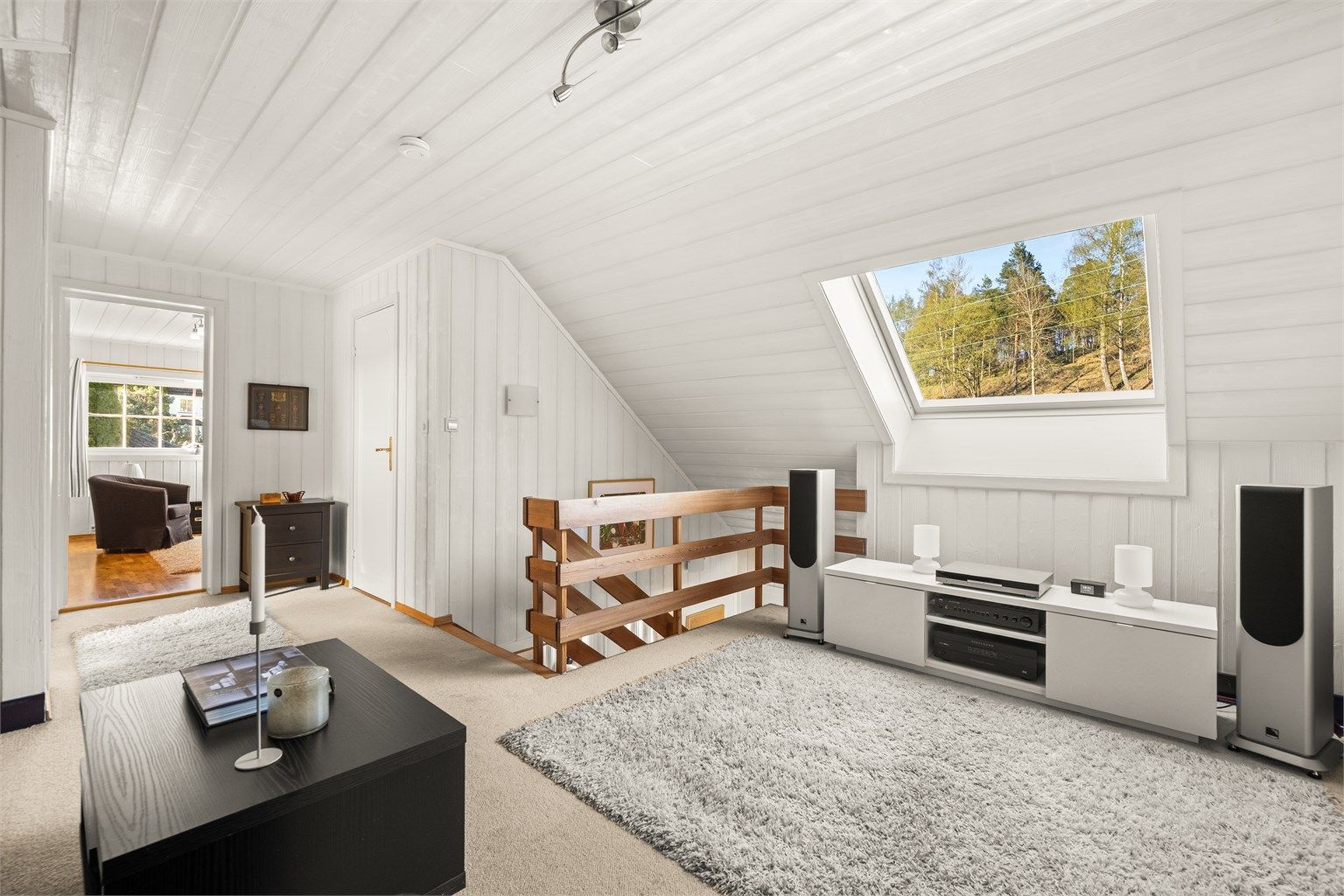 Fra loftstuen er det utsikt mot skogholtet og adkomst til etasjens øvrige rom.