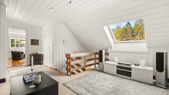 Fra loftstuen er det utsikt mot skogholtet og adkomst til etasjens øvrige rom.