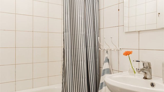 Innredningen består av vegghengt servantinnredning med ovenpåliggende servant, speil med overlys og stikkontakt, samt badekar med dusjarmatur, hånddusj og regndusj.
