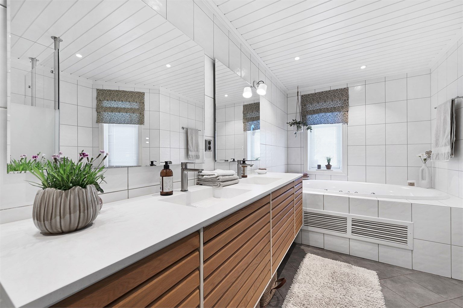 Hovedbadet i første etasje har innredning fra 2021, med doble servanter, innfliset badekar og vannbåren gulvvarme.