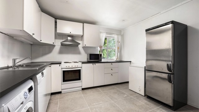 Kjøkkeninnredning med slette fronter fra 2017, benkeplate med laminert flate og nedfelt oppvaskkum i rustfritt stål med ett-greps armatur.