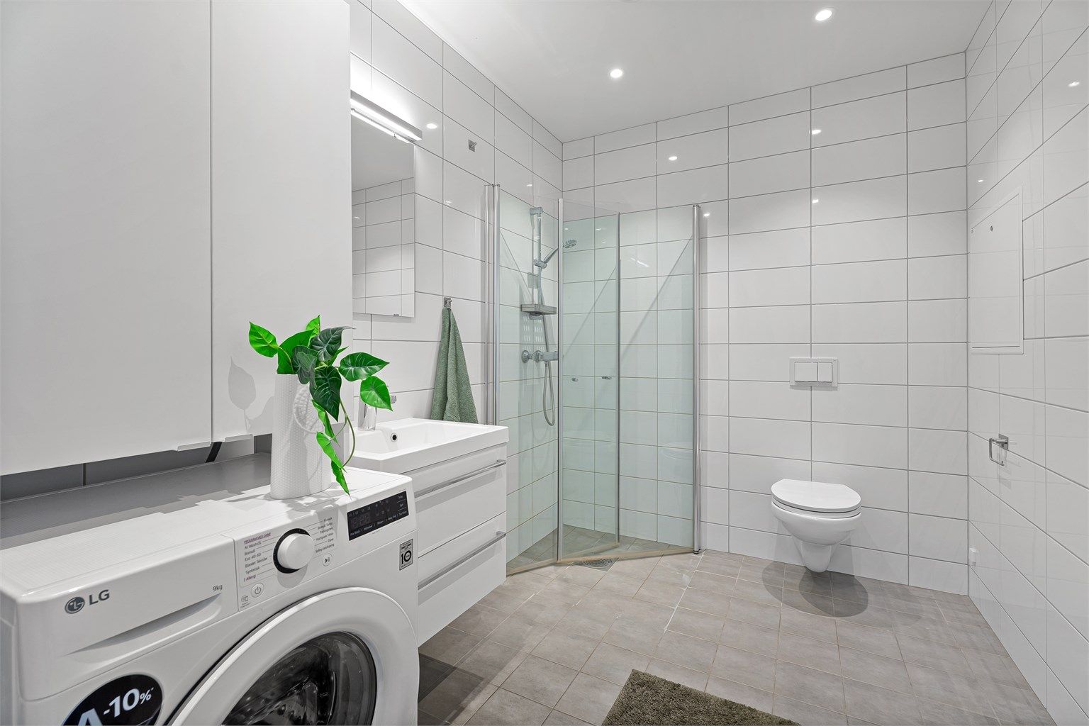 Flislagt og minimalistisk bad med varmekabler i gulv. 