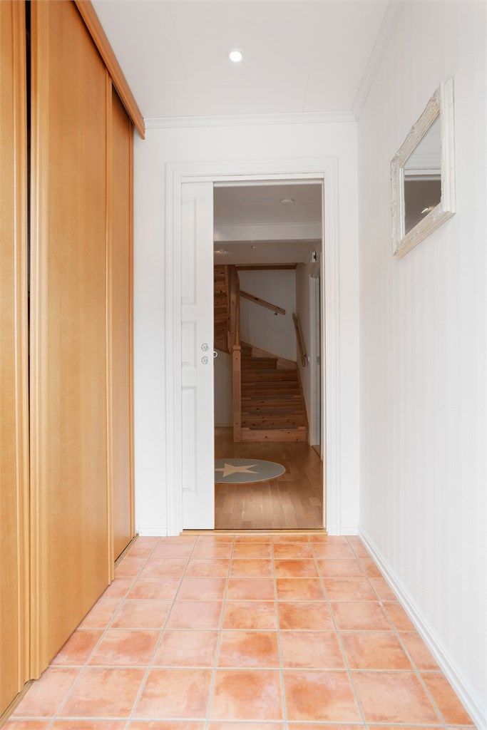 Entréen har fliser på gulv med varmekabler og skyvedørsgarderobe.