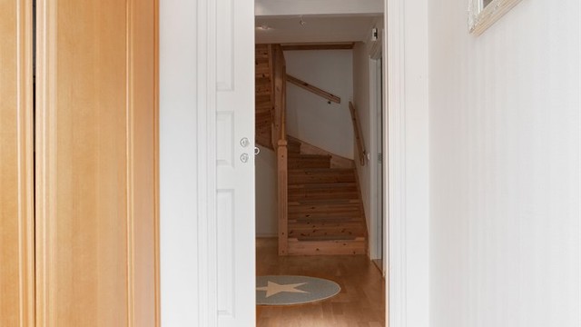 Entréen har fliser på gulv med varmekabler og skyvedørsgarderobe.