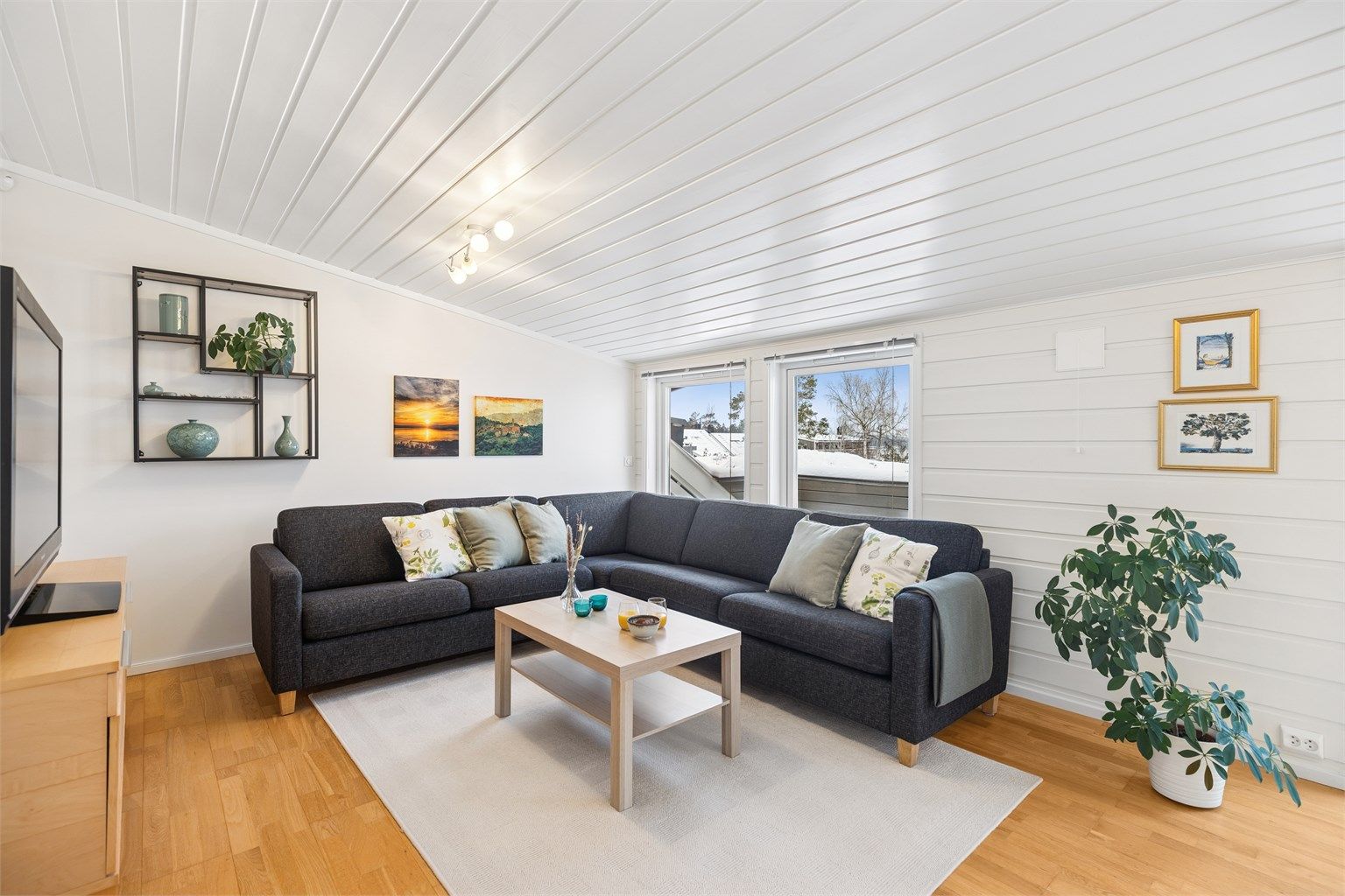 Loftstuen er et funksjonelt og fleksibelt rom med god plass til både en romslig sofa og en hyggelig lesekrok.