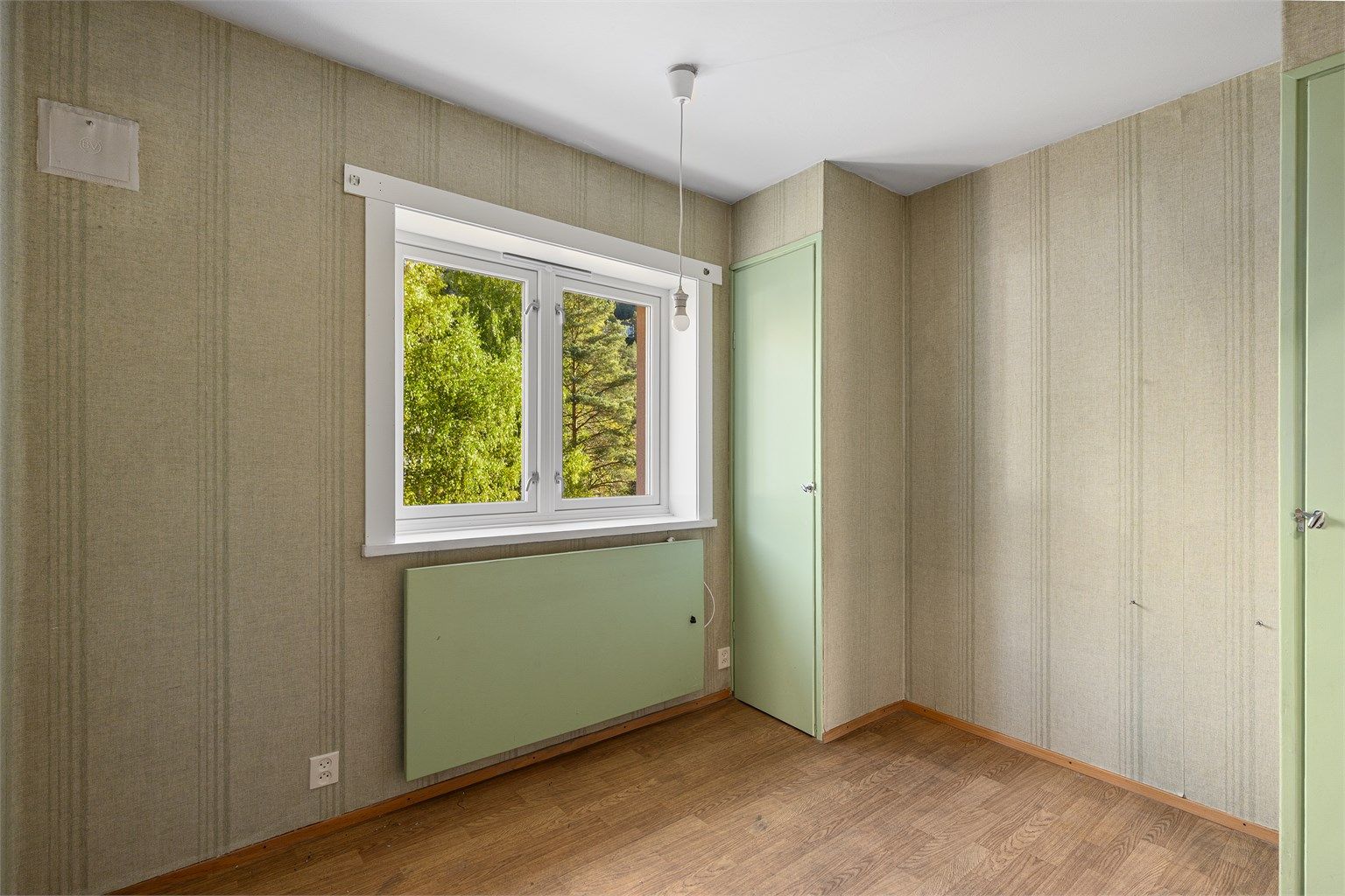 Soverom 2 med plassbygd garderobe og utsikt mot grønne omgivelser.