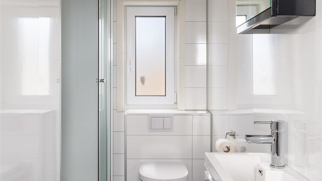 MINIMALISTISK: På badet i 2. etasje er det sort belegg på gulvet og hvite våtromsplater på veggene.