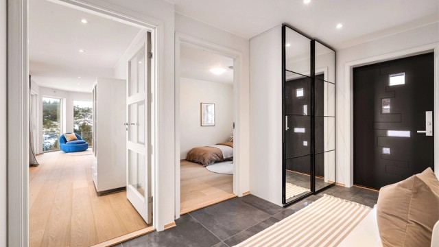 - Romslig entré/gang med skyvedørsgarderobe. Lekker innredning med store, grå fliser og svarte detaljer på garderobe og ytterdør. -