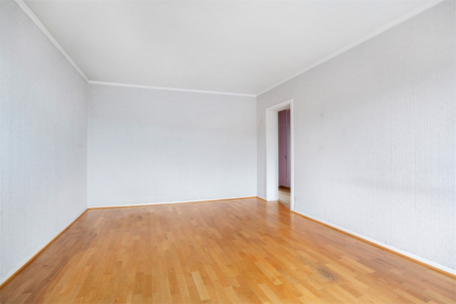 Romslig stue med plass til sofa, bord, TV og tilhørende møblement. 