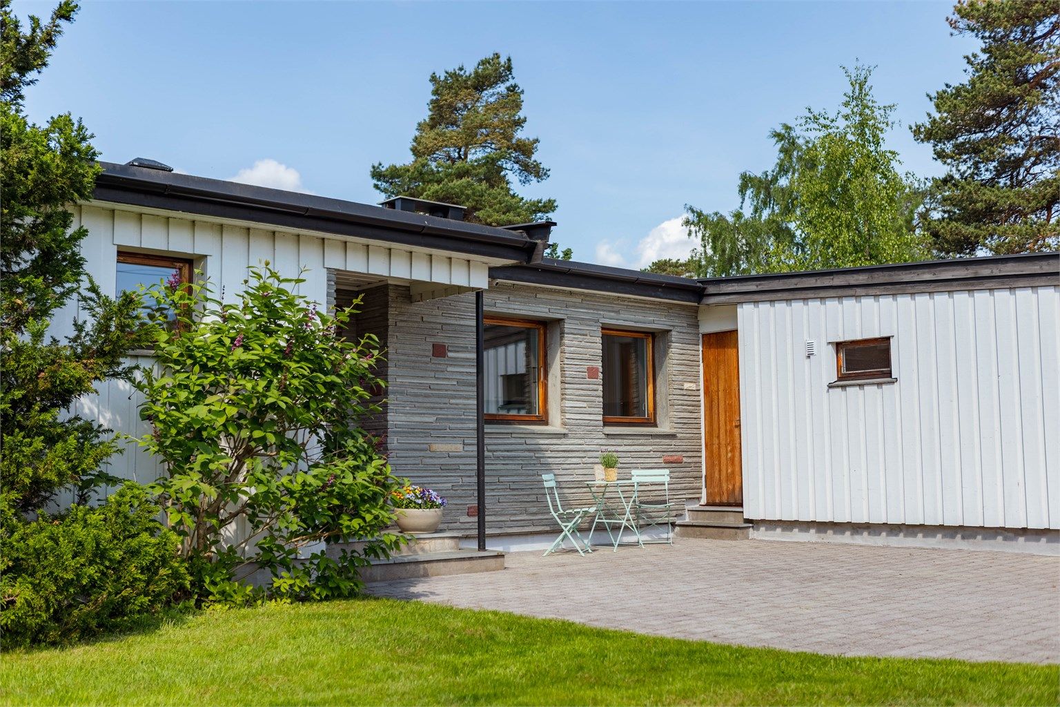 Boligen har et særpreget og tidsriktig uttrykk med en spennende kombinasjon av stående trekledning og murte fasader.