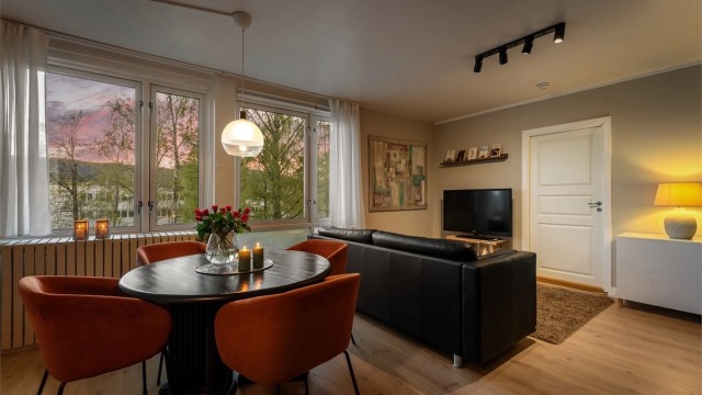 Leiligheten har en innbydende og hyggelig stue med mye naturlig lys