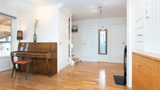 Hallen har trapp til etasjene over og under samt adkomst til soverom og bad.