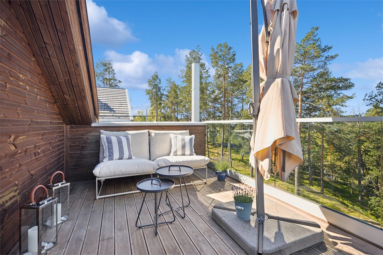 Den vestvendte takterrassen nyter sol fra ettermiddag til solnedgang, og danner en perfekt ramme for avslapning og utsikt over omgivelsene. Glassrekkverket gir både trygghet og en åpen følelse.