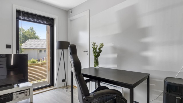 Stuen har plass til både sofagruppe og en egen kontorkrok med smart plassering.