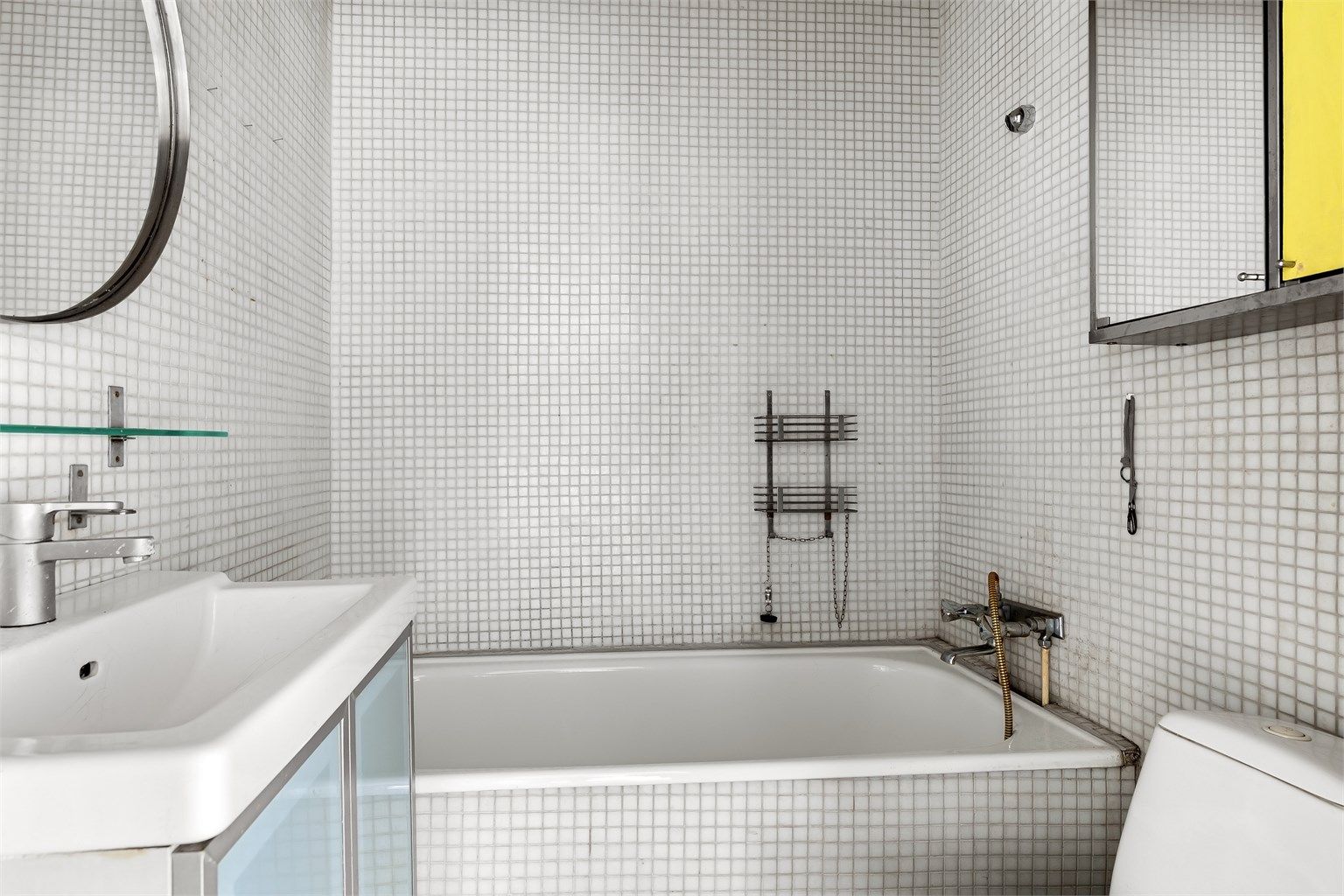 Badet er utstyrt med badekar, servant med underskap og toalett.