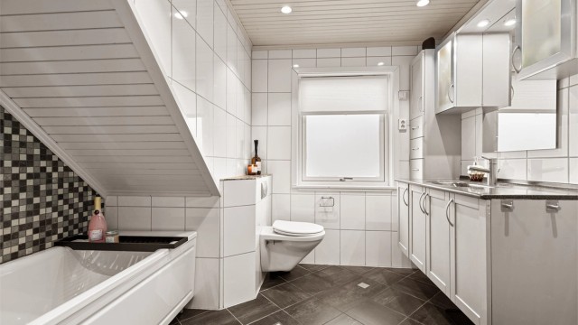 Flislagte overflater med gulvvarme og innfelte downlights i panelhimling.