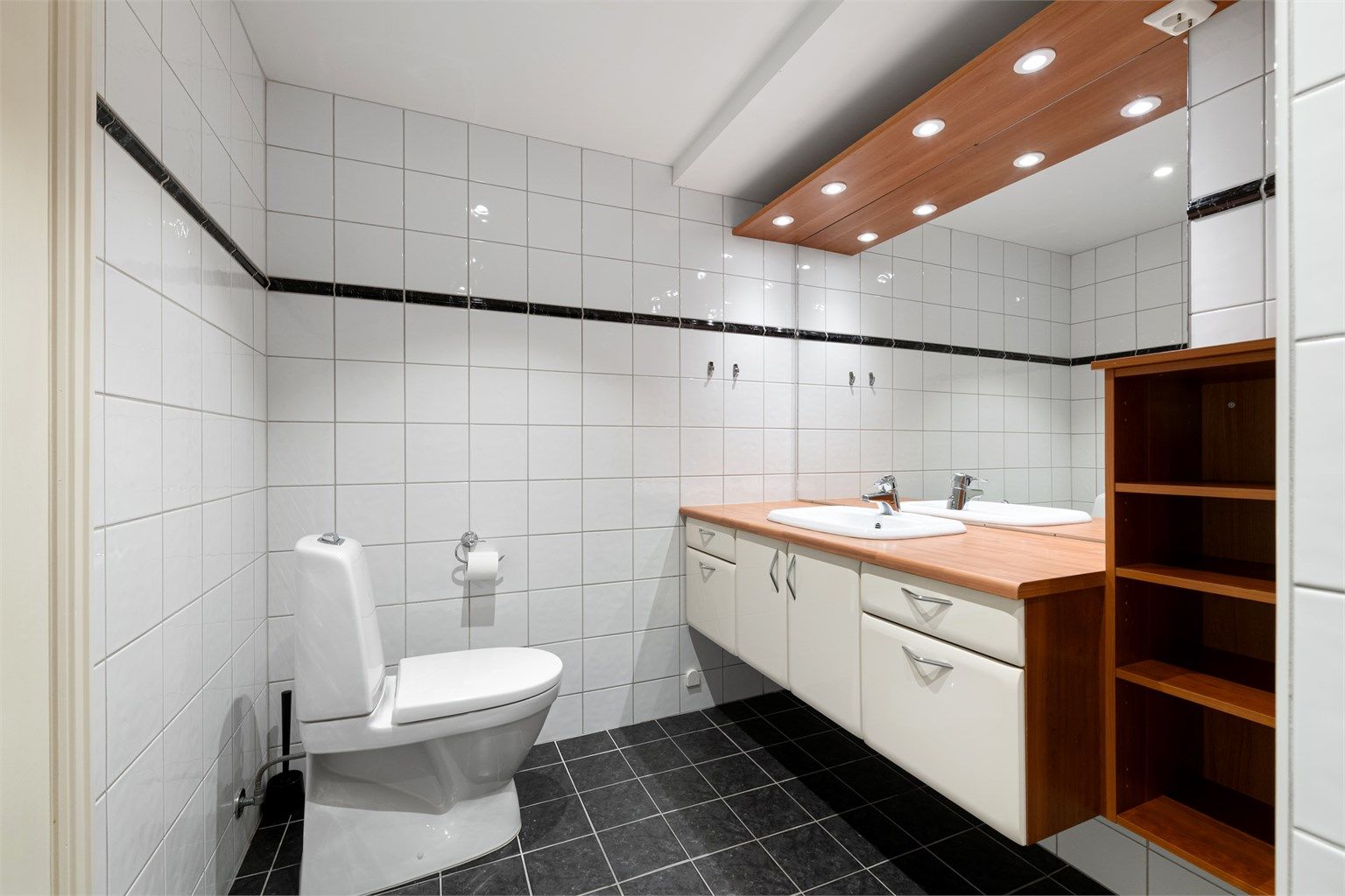 Badet er utstyrt med innfelte downlights, speil med belysning og gulvstående toalett.
