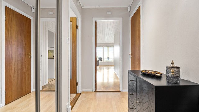 Gang med skyvedørsgarderobe og adkomst videre til oppholdsrommene.