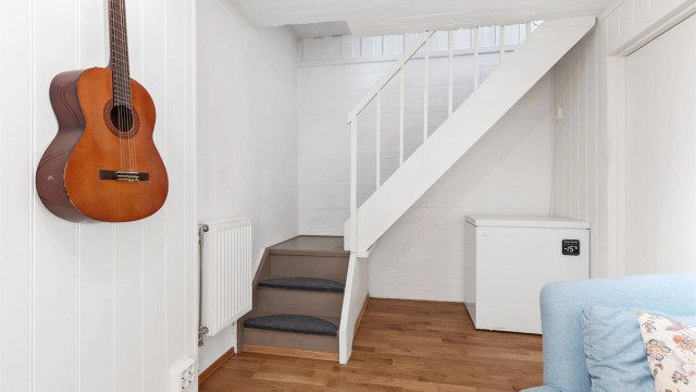 Rommet har parkett på gulvet og oppvarmes med radiator (Kjellerstuen er ikke godkjent for varig opphold)