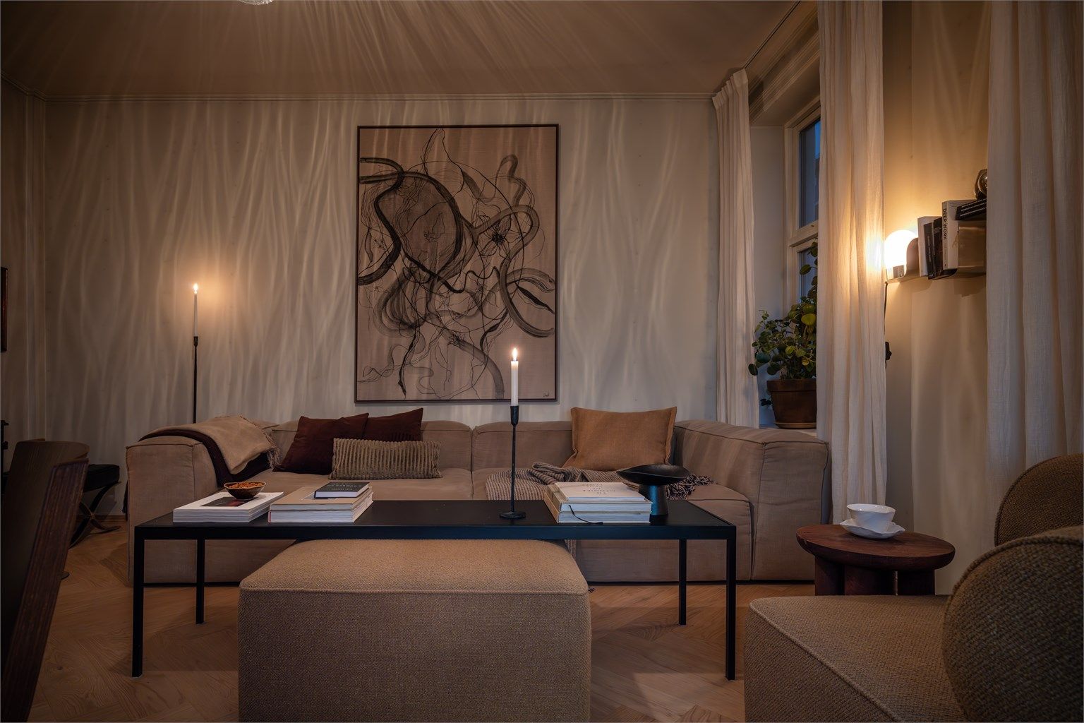 Et sosialt og lyst oppholdsrom med store, klassiske vinduer som slipper inn rikelig med naturlig lys.