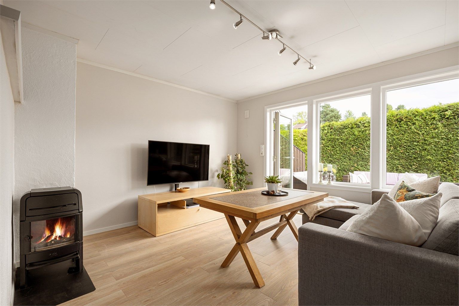 Leiligheten har en åpen stue- og kjøkkenløsning med peisovn og nye gulv.
Foto: [Eiendomsfoto AS]