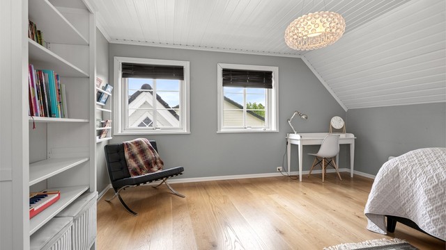 Et av de fire soverommene i loftsetasjen. Rommet har parkettgulv og plass til både seng og skrivepult.