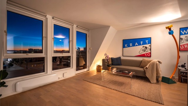 De store vindusflatene fanger solnedgangen over byen.