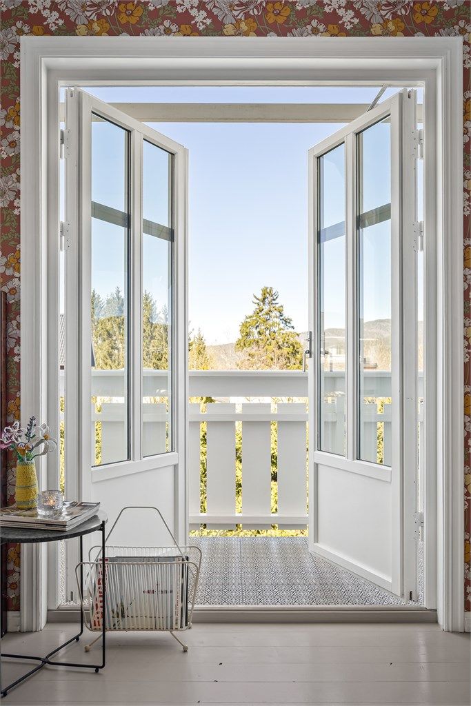 De to-fløyede balkongdørene fra loftstuen åpner opp mot nabolaget og slipper lyset inn.