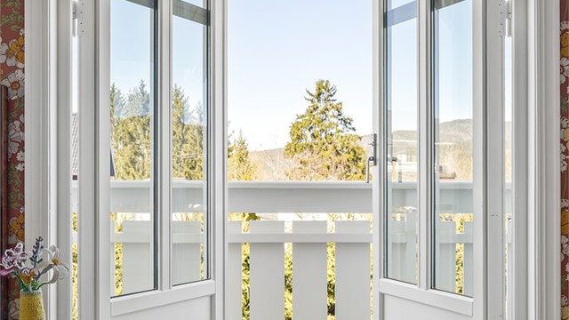 De to-fløyede balkongdørene fra loftstuen åpner opp mot nabolaget og slipper lyset inn.