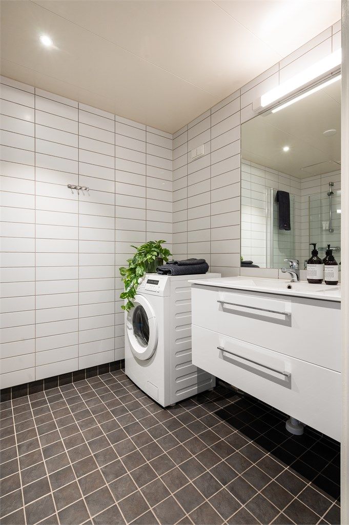 Badet har servant nedfelt i innredning, speil med belysning og opplegg for vaskemaskin.