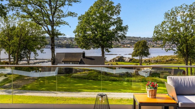 Fra stua er det utgang til en stor terrasse. Rekkverket er i glass så utsikten til fjorden kan nytes fullt ut.