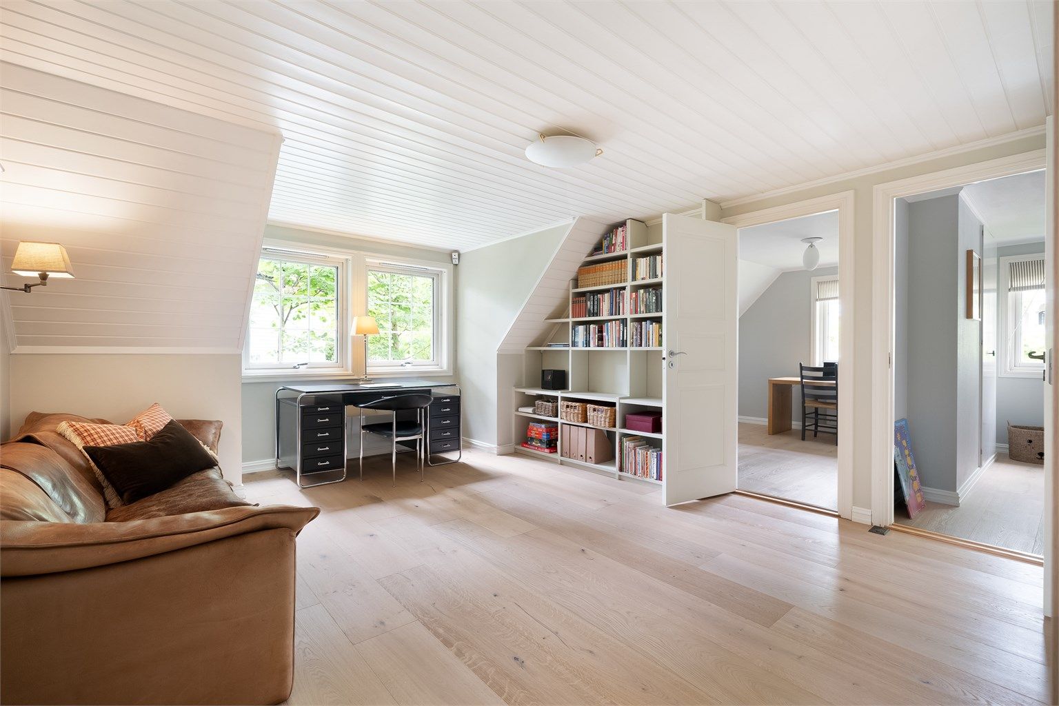 Videre er det satt inn en plassbygget bokhylle til ønsket innredning. Det er lagt parkett på gulvet. 