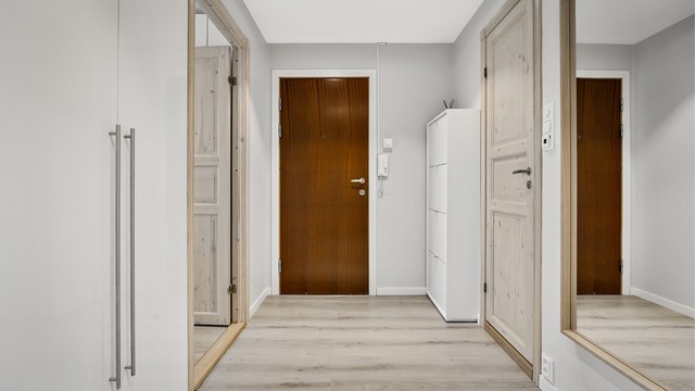 Innbydende entré med dørcallinganlegg som har åpnerfunksjon. Garderobe medfølger ikke.