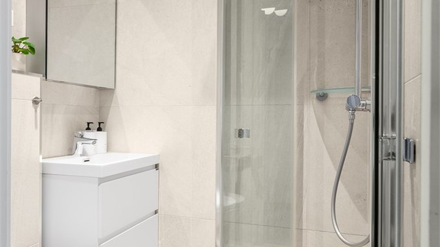 Delikate fliser på gulv og vegger, samt innfelte downlights i himlingen.