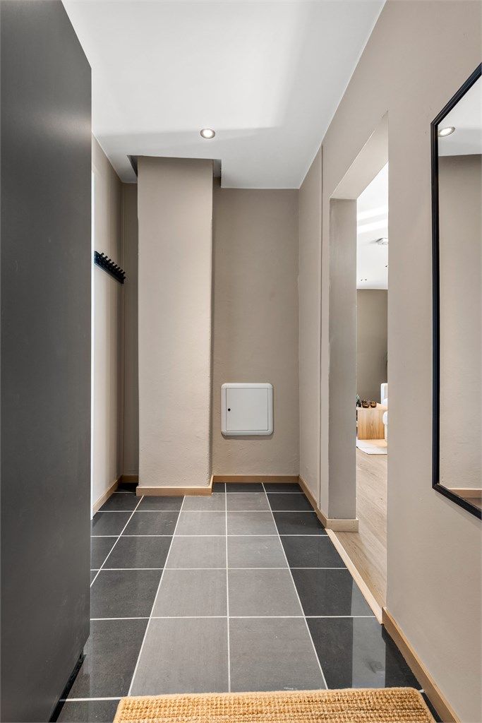 Fra entréen er det åpen tilgang videre inn i stuen og til badet. Leiligheten har en smarthusløsning for styring av varme.