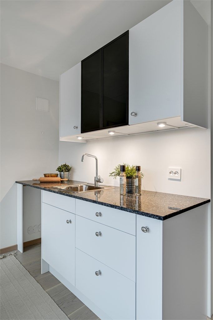 Den enkle kjøkkeninnredningen har glatte fronter og integrerte spotter.