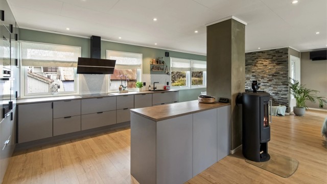 Det åpne allrommet er boligens naturlige samlingspunkt. På gulvet er det laminatgulv og downlights i taket.