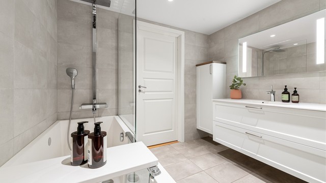 Badet er utstyrt med badekar med både regn- og hånddusj, vegghengt toalett og en bred servantinnredning