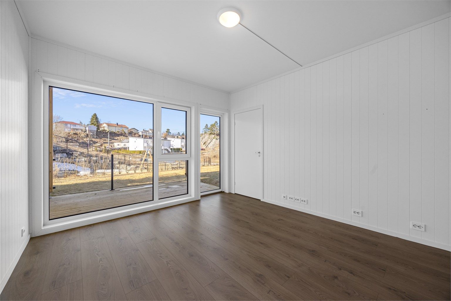 Leiligheten er en treroms med store vindusflater og god takhøyde flere rom.