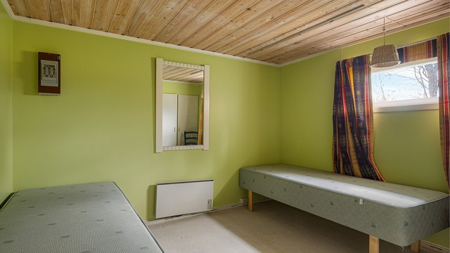 Innredet rom i kjelleretasjen med panel i himling.