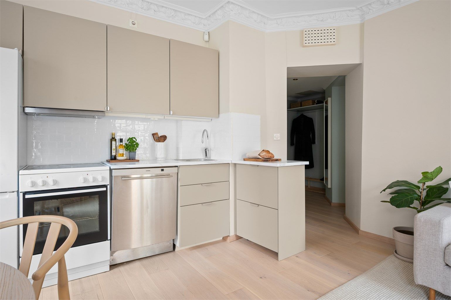 Kjøkkenet fra Ikea er både stilrent og praktisk, og ligger i åpen løsning mot stuen.  Innredningen har nye, glatte fronter fra 2024 og benkeplate i heltre med kontaktplast.
