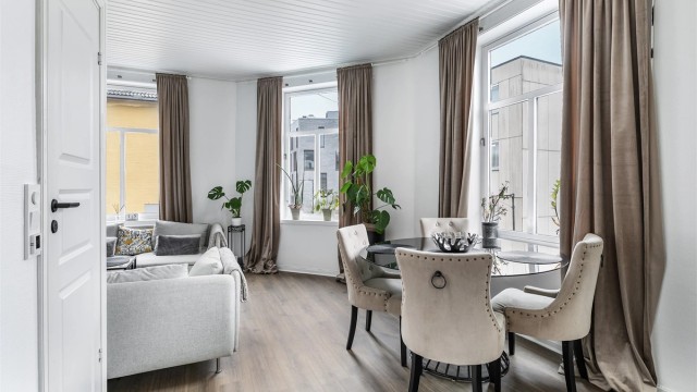Høyreiste og atmosfærefremmende krysspostvinduer fyller stuen med naturlig lys fra tre vinkler.
