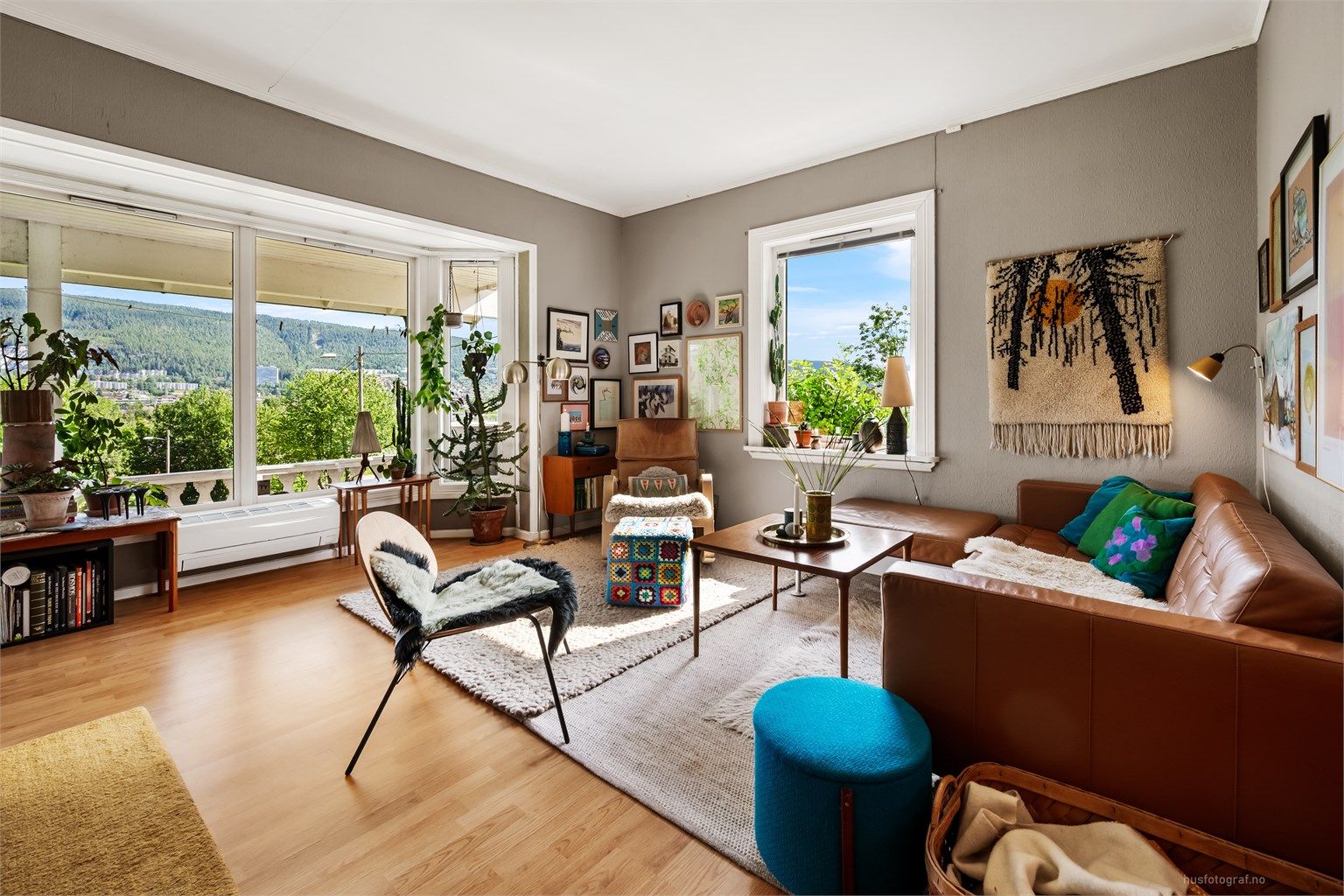 Romslig stue med plass til en stor sofagruppe og med gulvflater belagt med laminat.