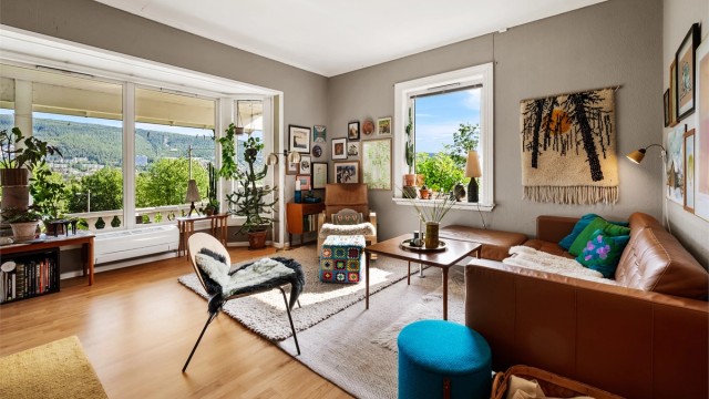 Romslig stue med plass til en stor sofagruppe og med gulvflater belagt med laminat.