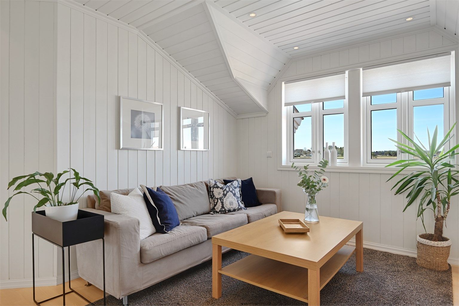 Loftstuen har panel på vegger og i tak, noe som gir en lun og hyggelig atmosfære.