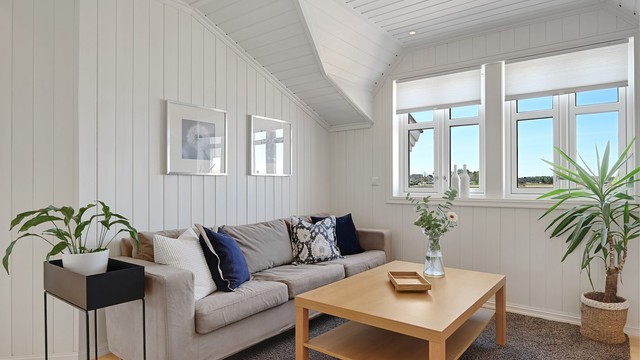 Loftstuen har panel på vegger og i tak, noe som gir en lun og hyggelig atmosfære.